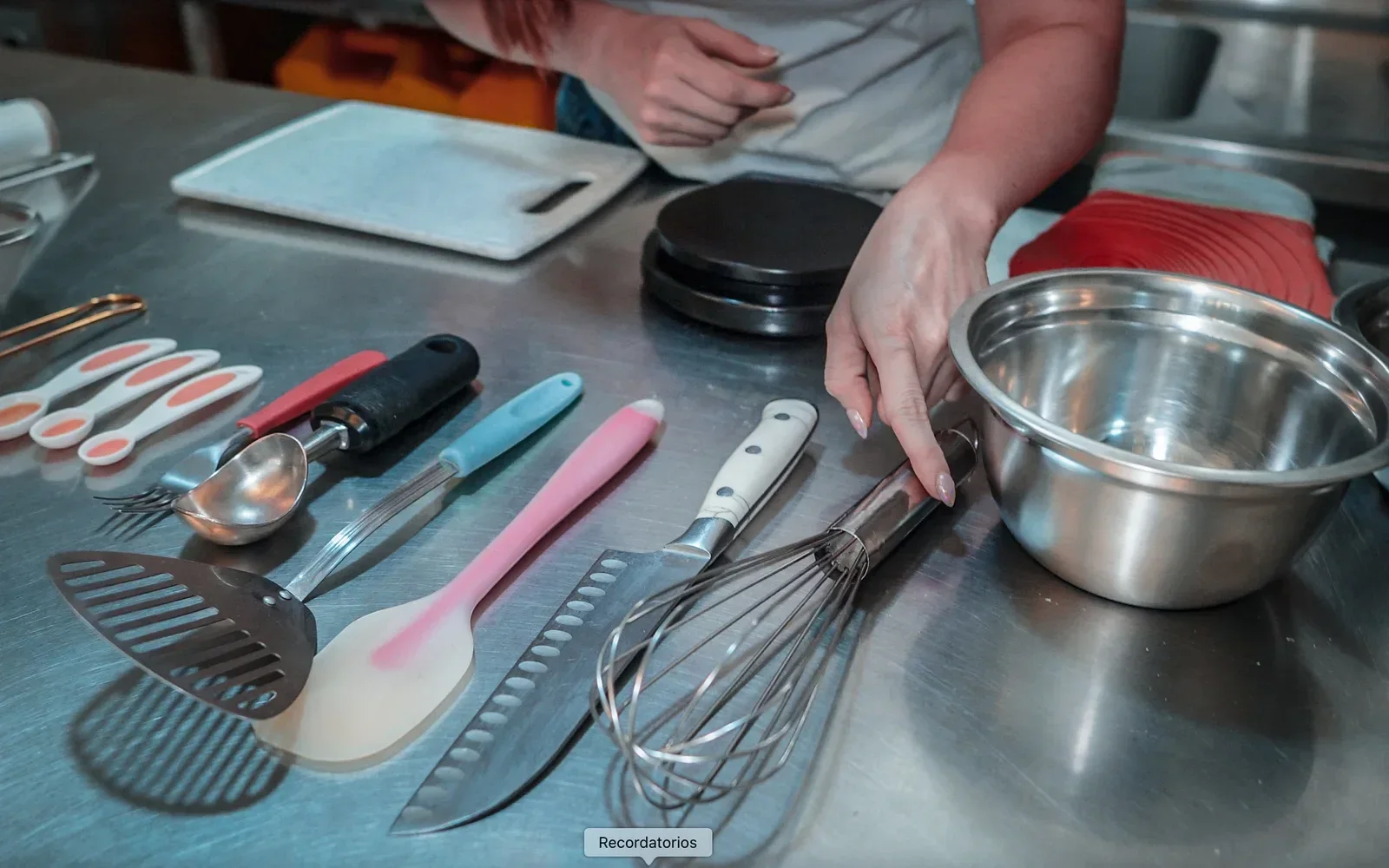 Balanza, espátulas, batidor y recipientes sobre la mesa de trabajo