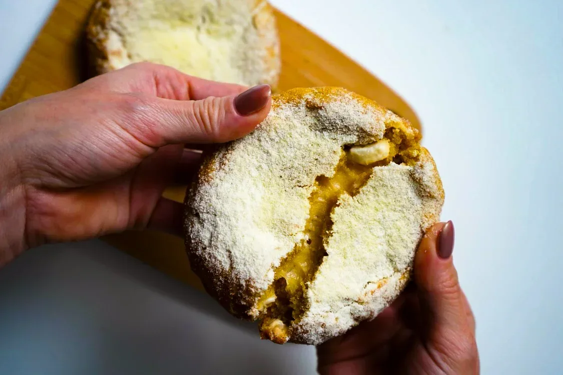 Cookie cubierta de azúcar impalpable, abierta para mostrar el interior